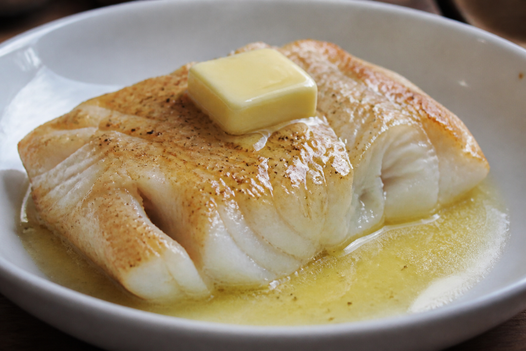 Cabillaud blanc dans un plat, noisette de beurre fondante