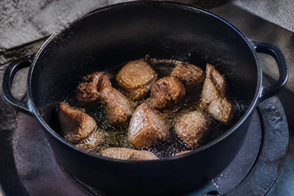 Morceaux de viande dores dans une marmite noire