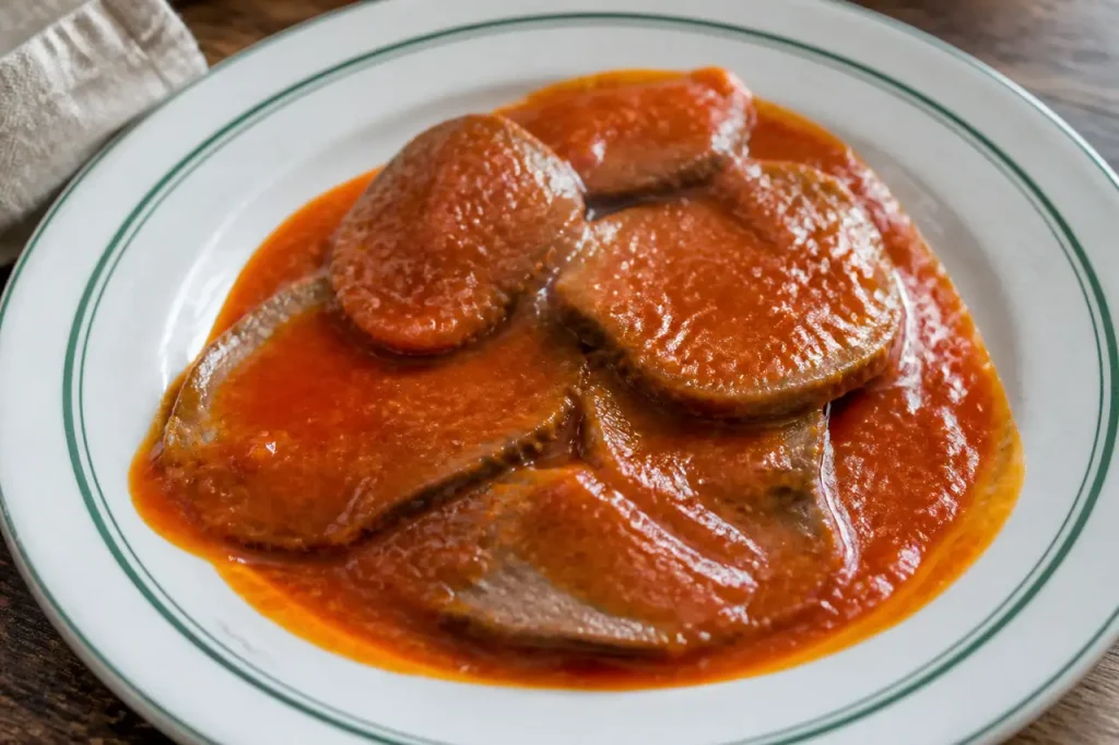Tranches de langue de boeuf nappees de sauce rouge